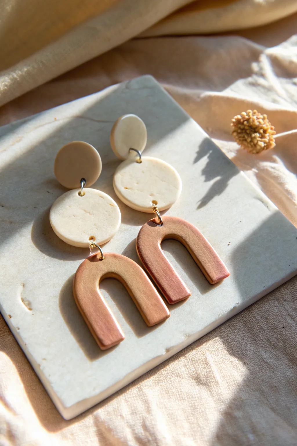 Minimal poured polymer clay earrings in simple shapes, glossy finish, soft Scandinavian tones.