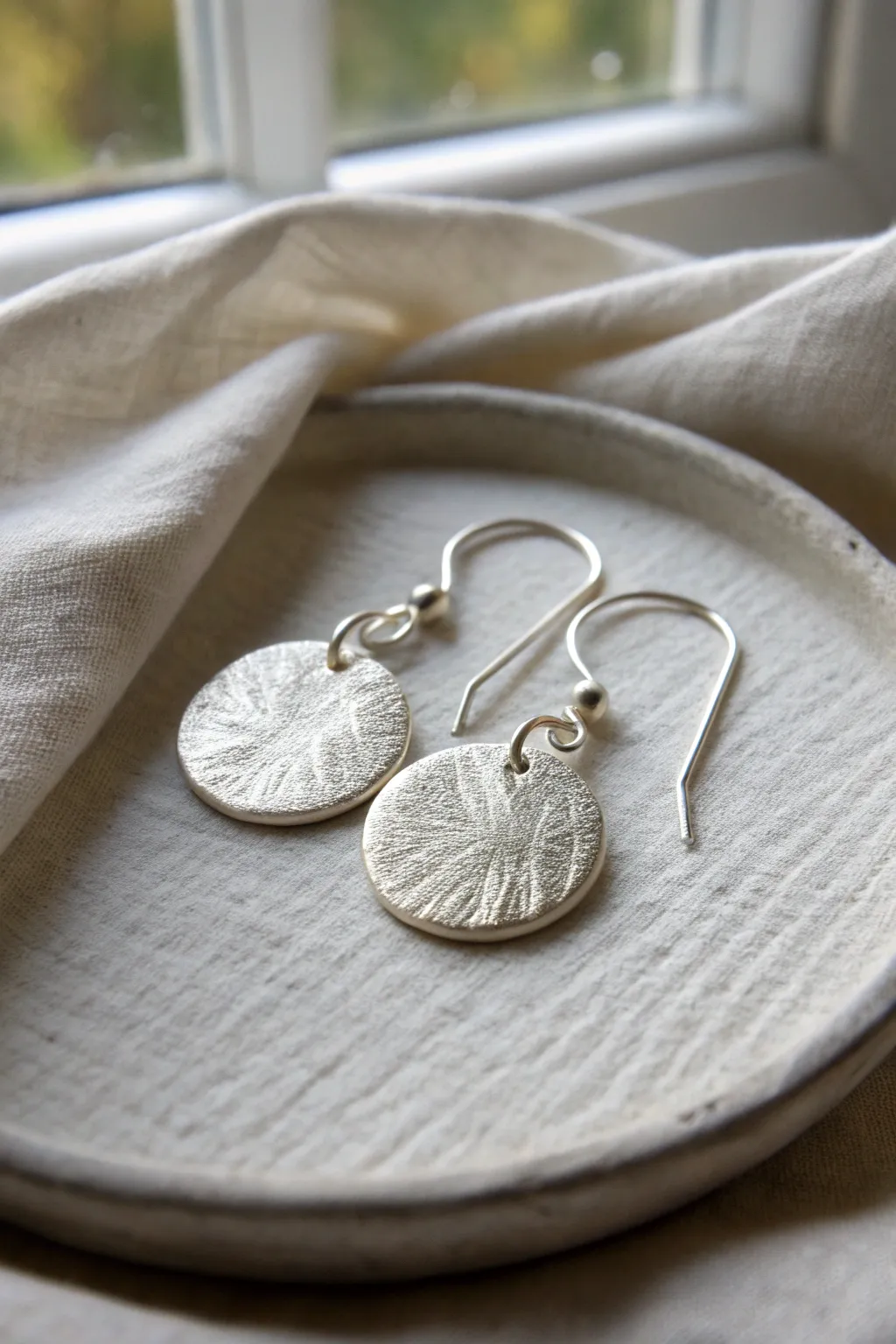 Textured metal clay disc earrings with a satin finish, minimalist style and natural artisan detail