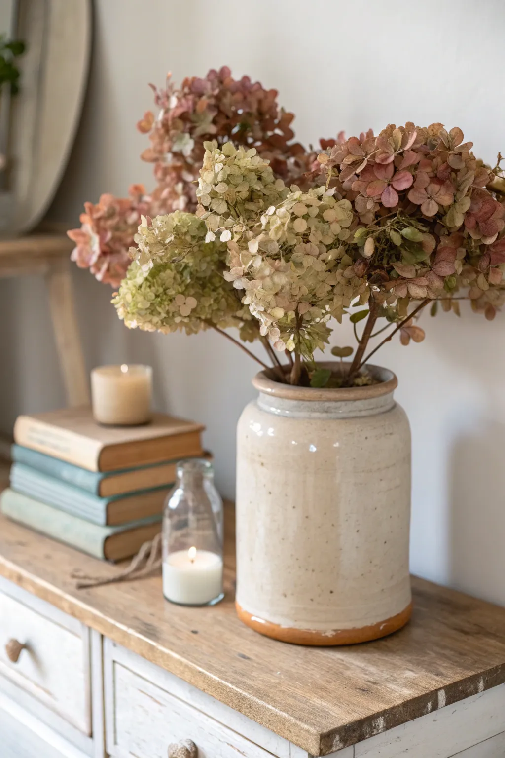 Vintage crock with dried hydrangeas adds soft rustic texture to a calm, minimalist vignette.