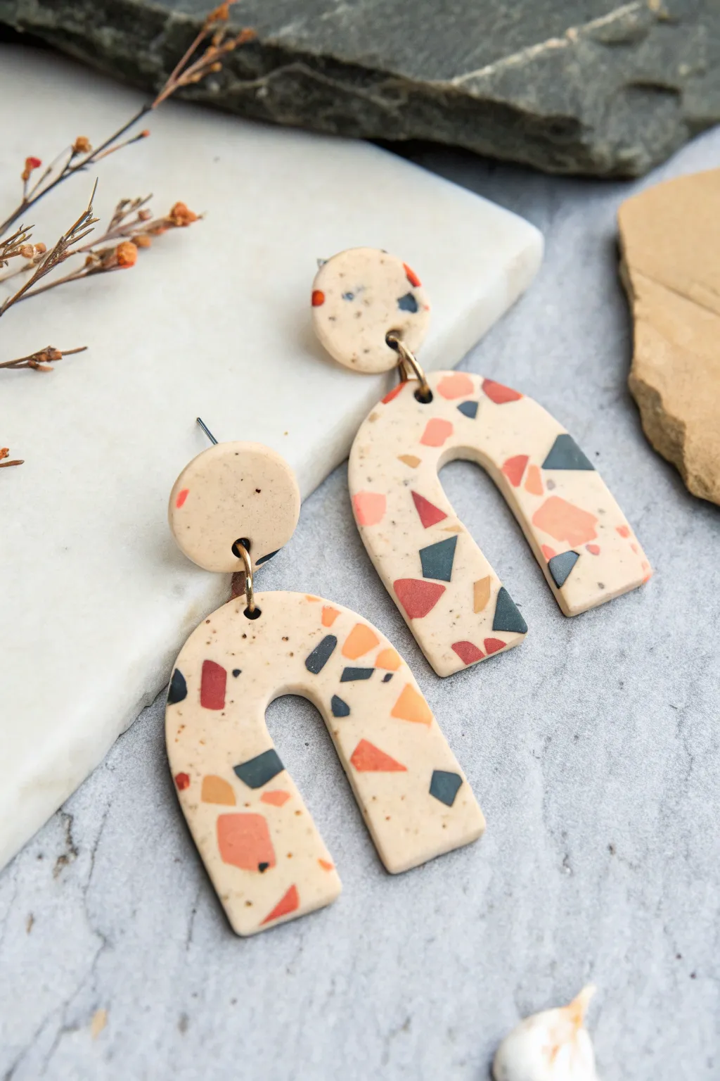 Terrazzo-speckled polymer clay drop earrings in a clean Scandinavian flatlay with bold contrast