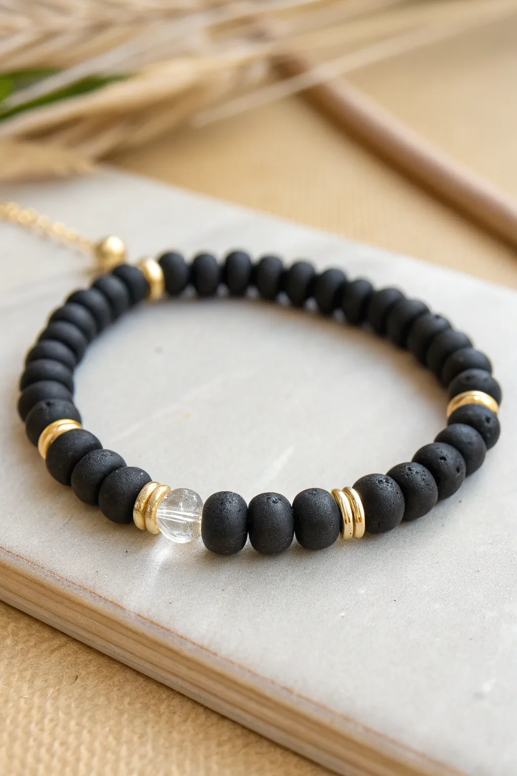 Minimal monochrome polymer clay disc bead bracelet with tiny gold spacers on soft linen