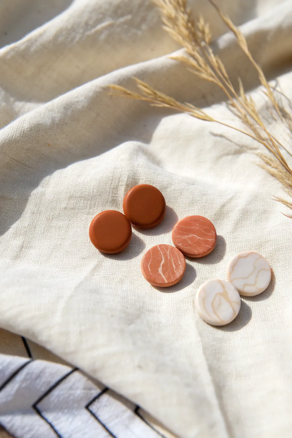 Beginner-friendly flat circle studs in solid and marbled polymer clay, styled on linen