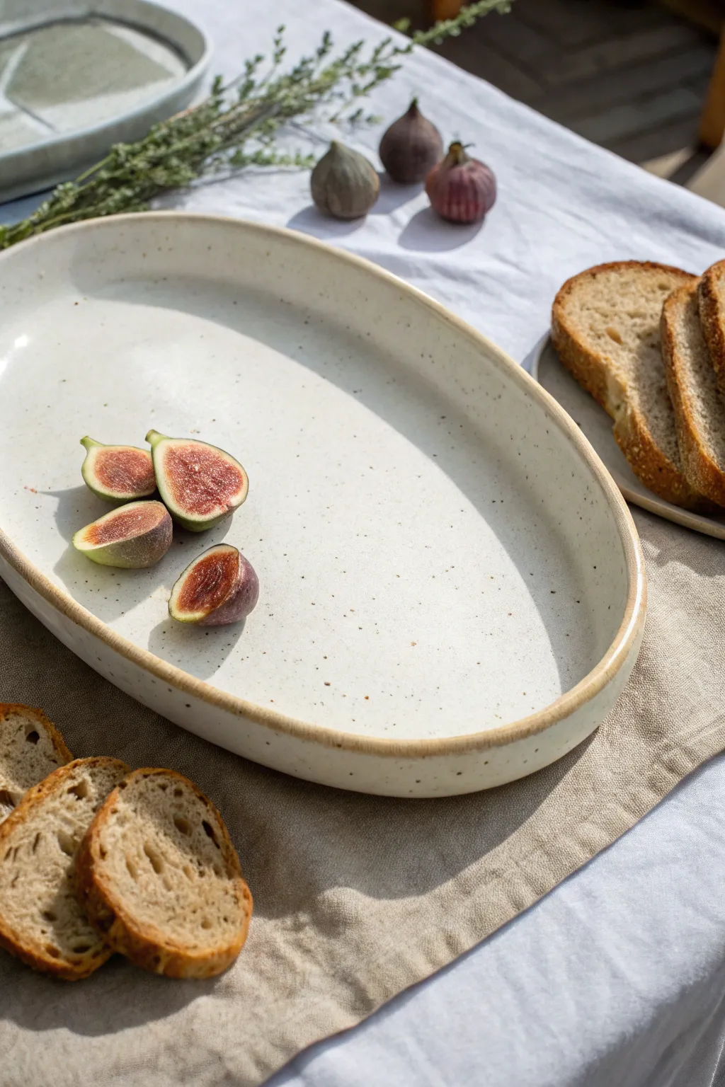 Simple oval slab platter with satin glaze, styled with bread and fruit for effortless serving