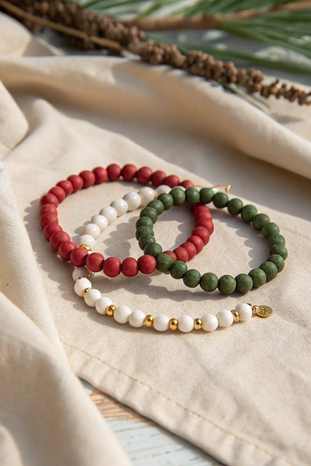 Preppy red, green, and white clay bead bracelets with tiny gold spacers in clean holiday style.
