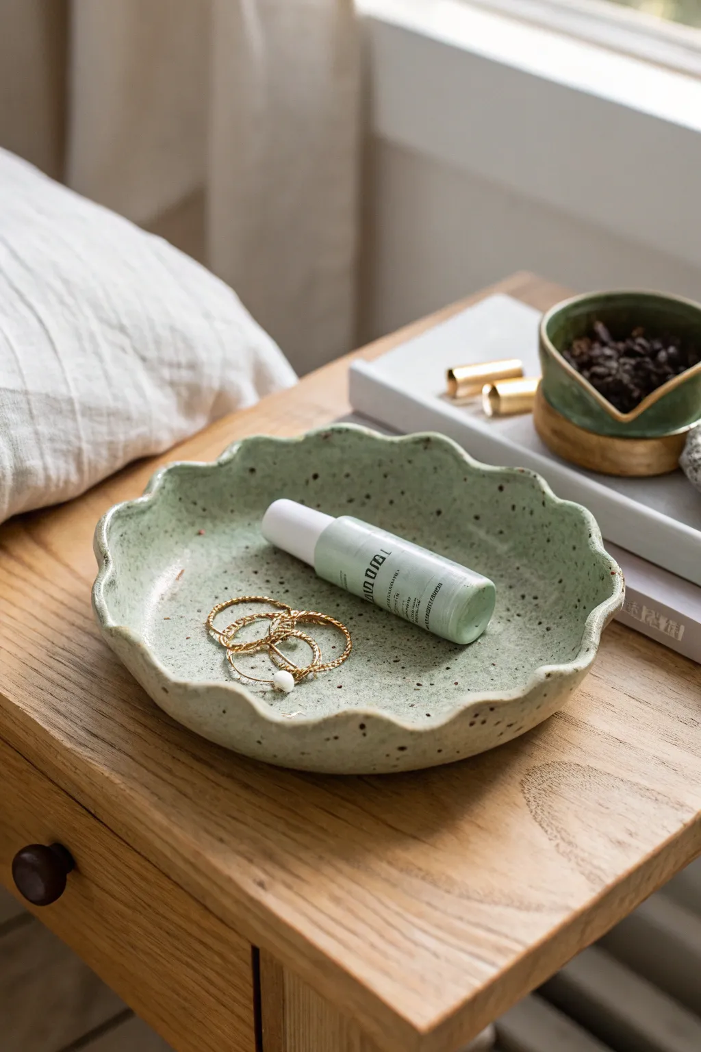 Sage green wavy-edge clay catchall tray with speckles, perfect for pins and balm.