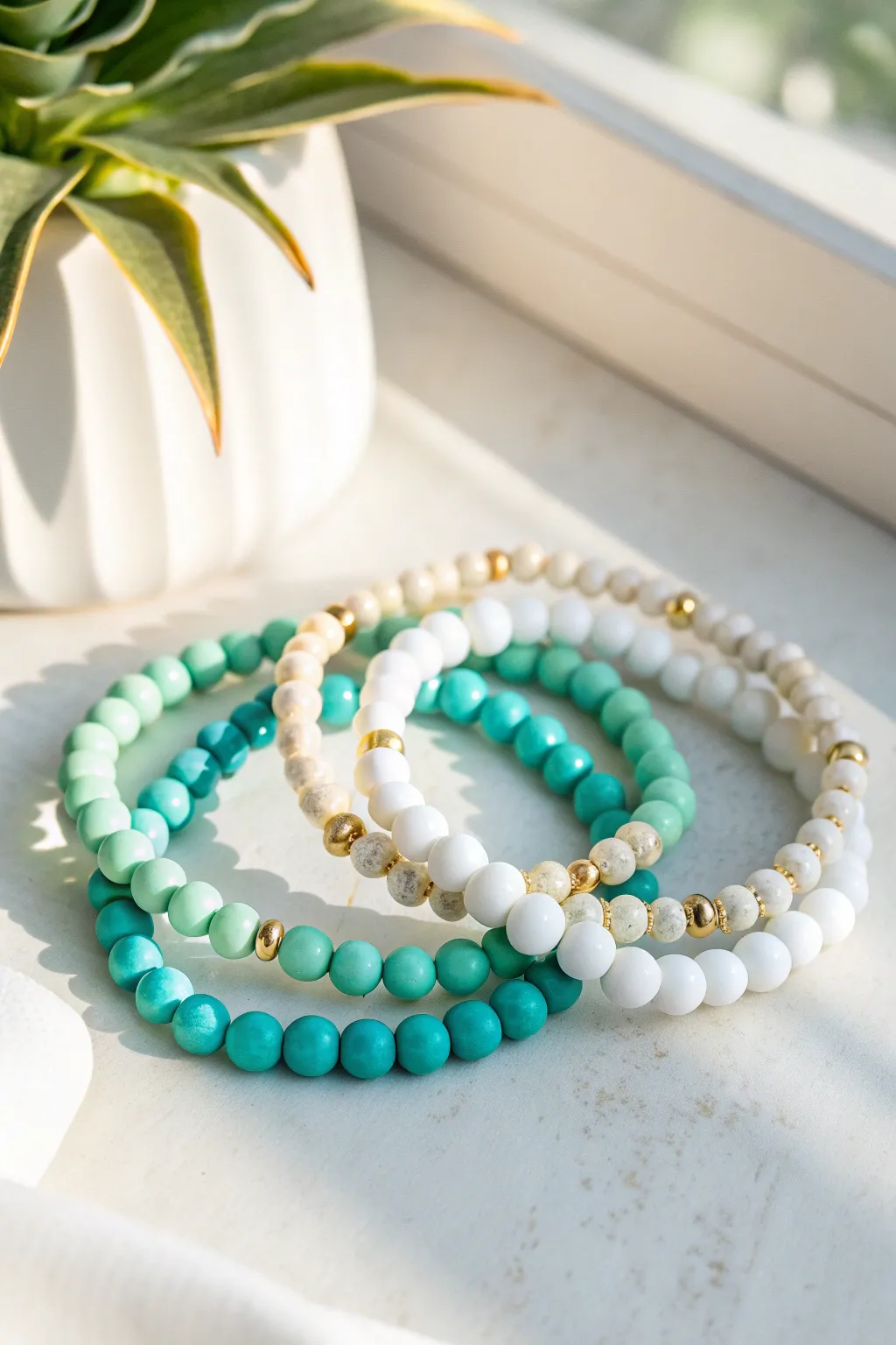 Teal and seafoam clay bead bracelets with gold spacers for an effortless beach-prep vibe