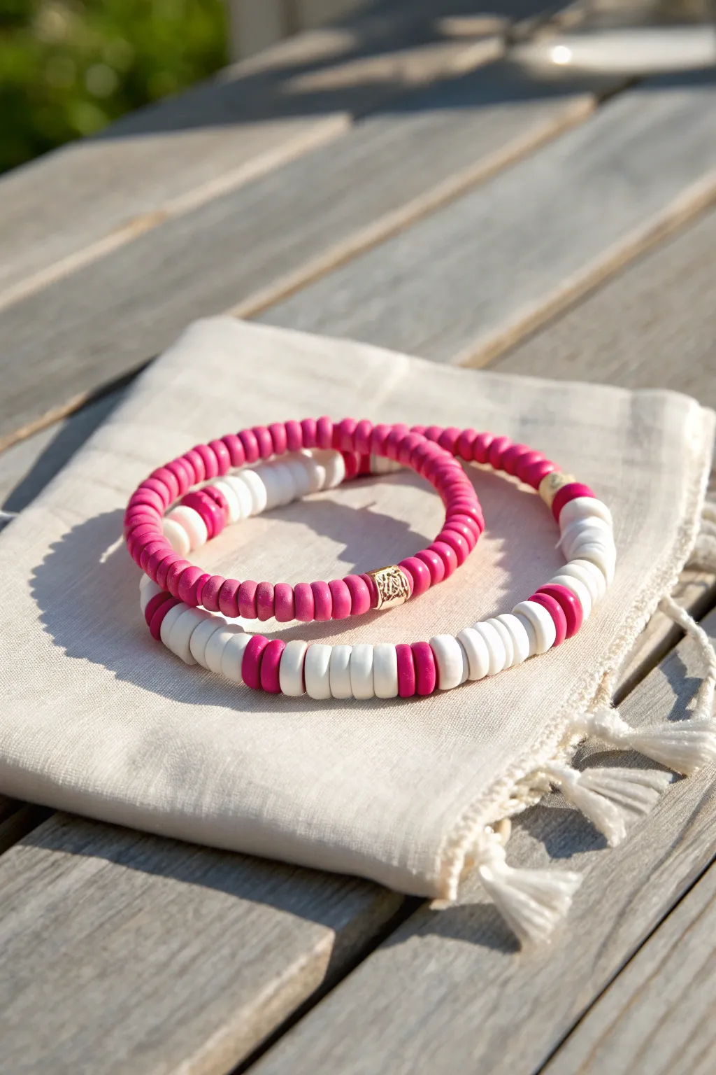 Hot pink and white clay disc bead bracelets stacked for a crisp preppy summer stripe look.