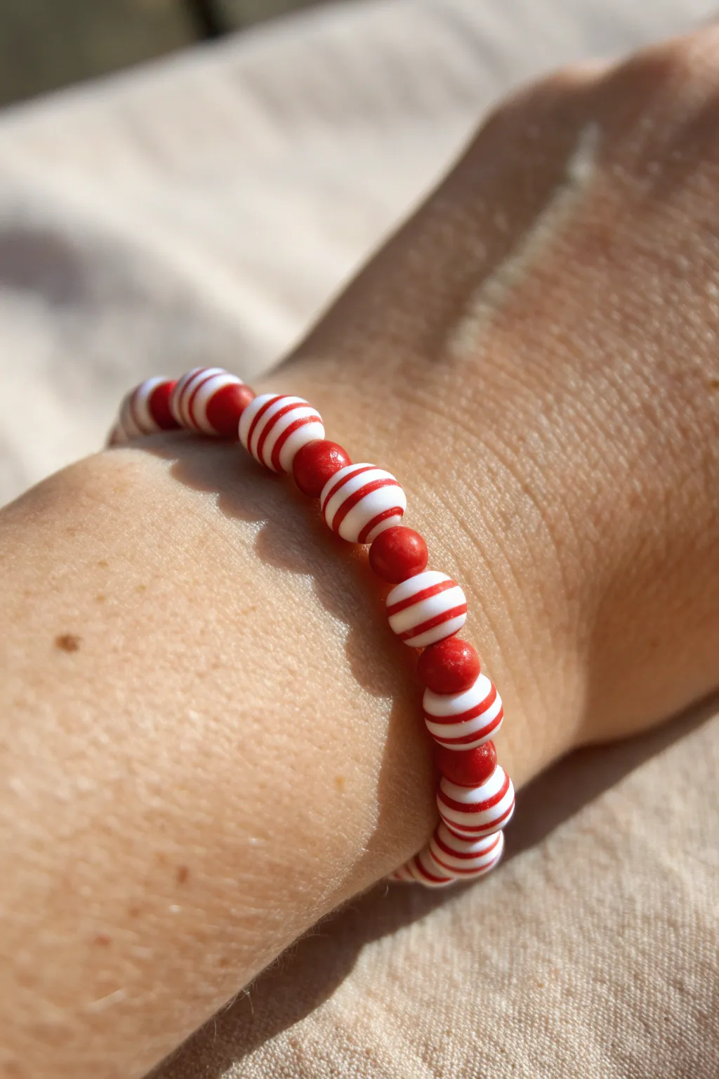 Playful red and white candy-stripe clay bead bracelet for a bright minimalist boho look