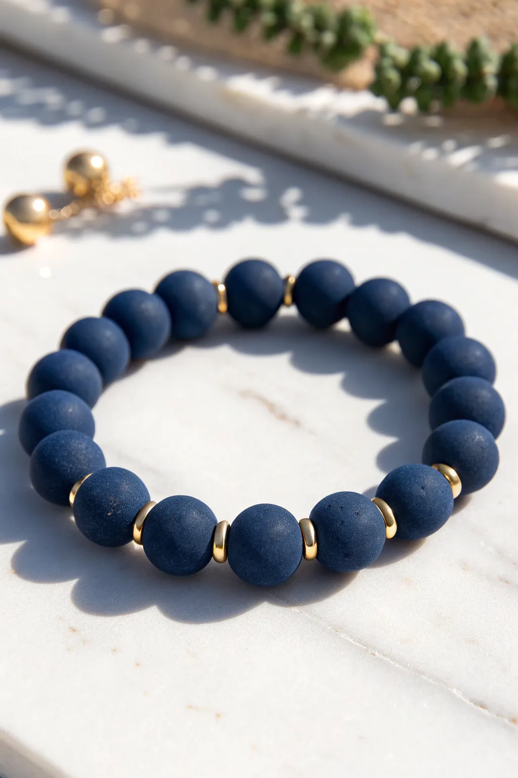 Navy clay bead bracelet with subtle gold spacer accents, minimalist boho elegance.