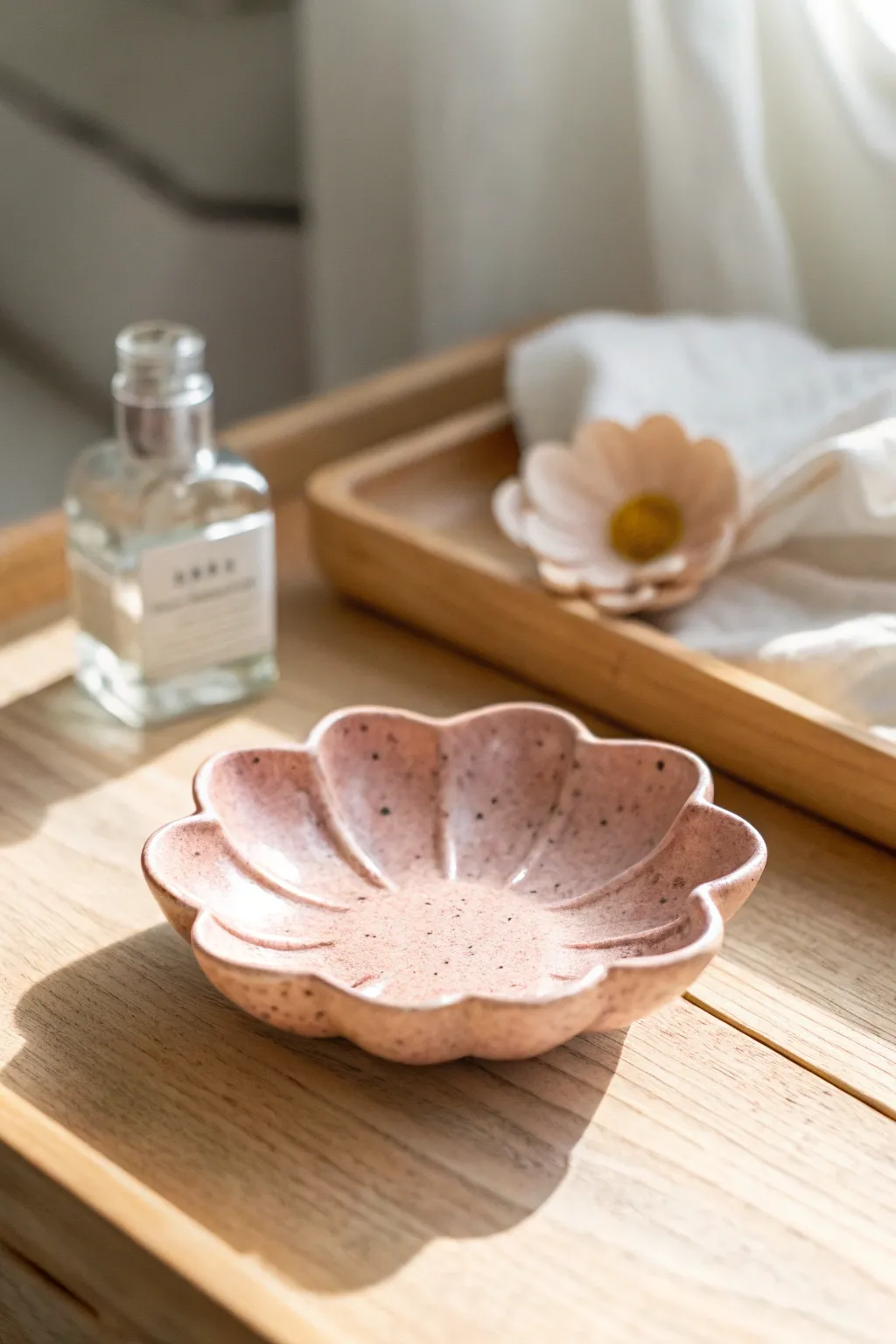 Blush scalloped flower petal dish in calm Nordic styling, softly lit for a cozy bedside vibe