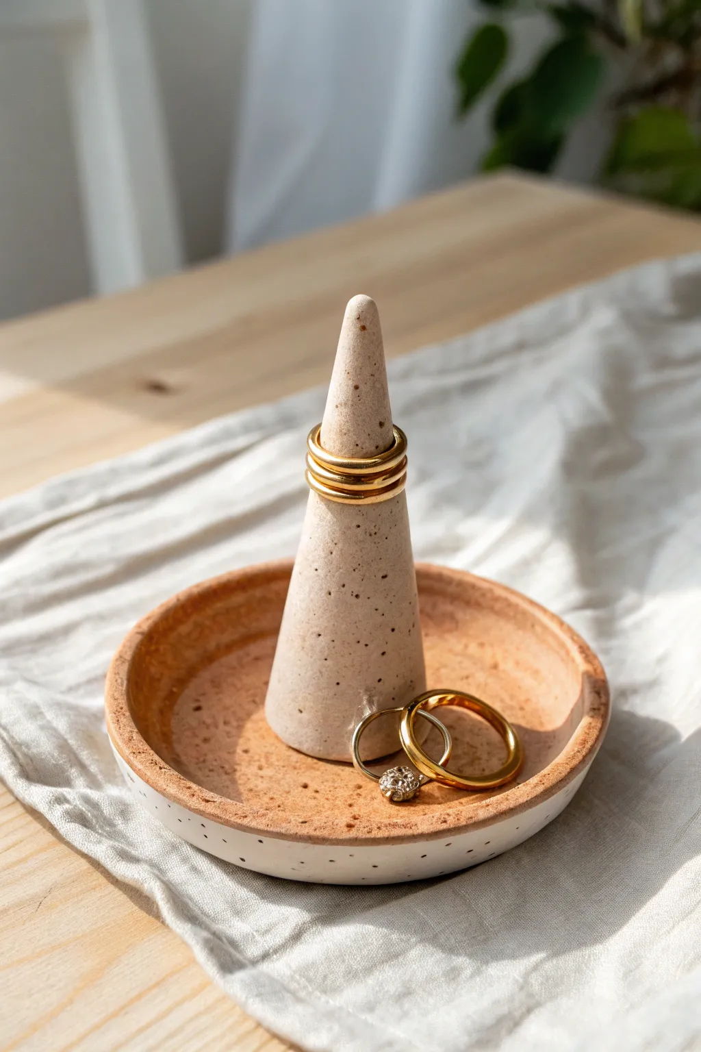 Minimalist air dry clay ring holder in earthy tones, chic cone-and-dish design for rings