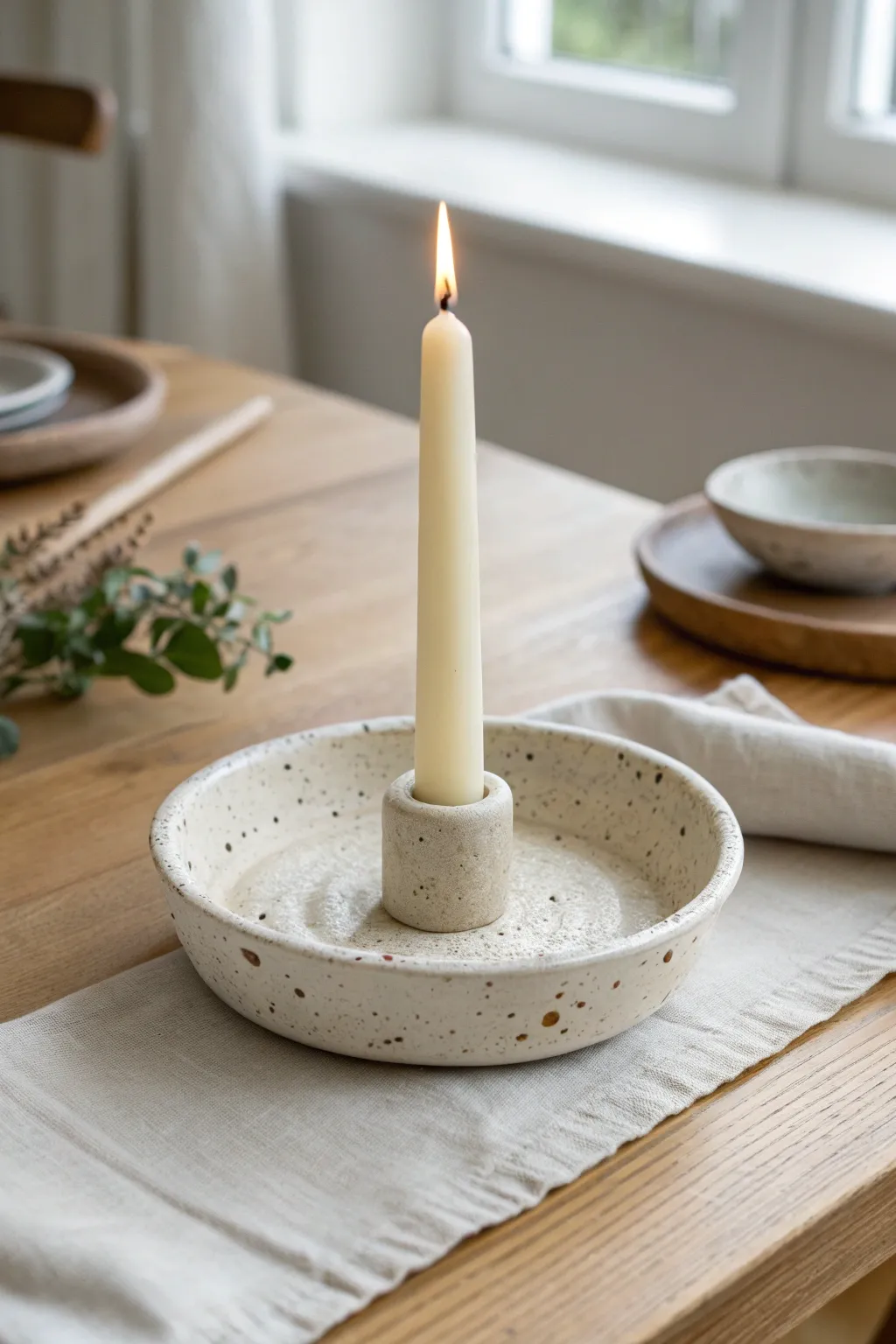 Minimal air dry clay drip-catch candle holder in matte off-white, softly lit and elegant.