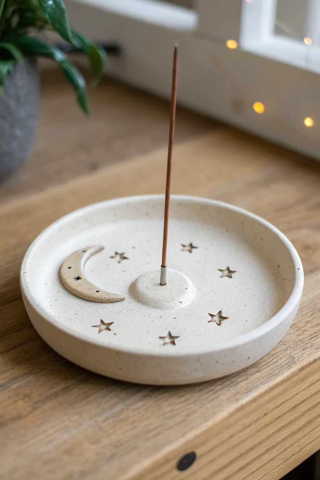 Minimal moon and stars catchall incense holder in air dry clay, softly lit on warm wood