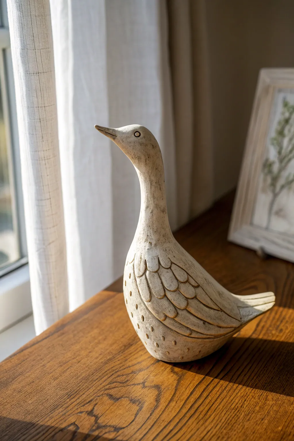 Graceful clay bird sculpture with carved feather texture, softly lit on warm wood.