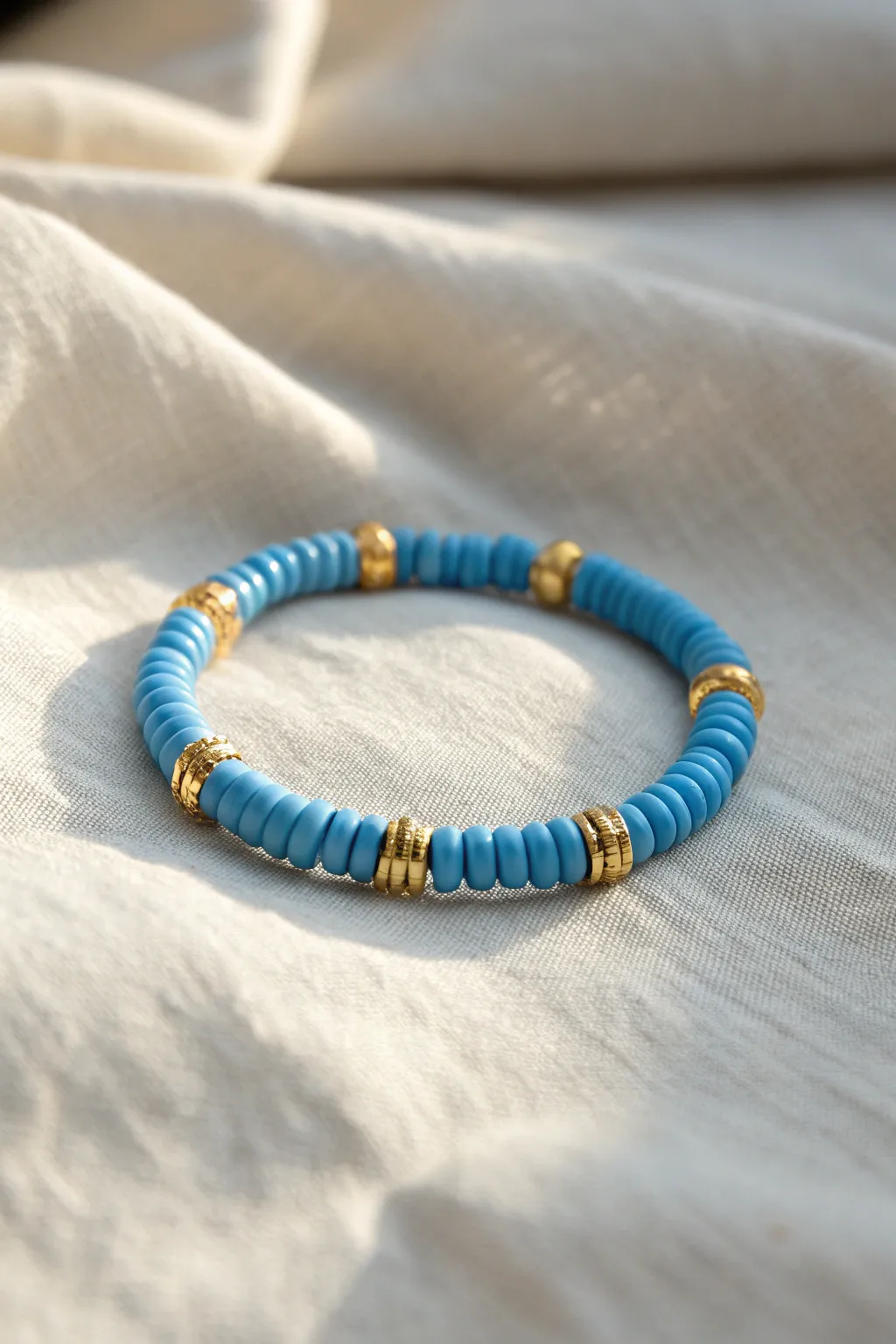 Blue heishi clay bracelet with evenly spaced gold spacers for a bright, minimal statement