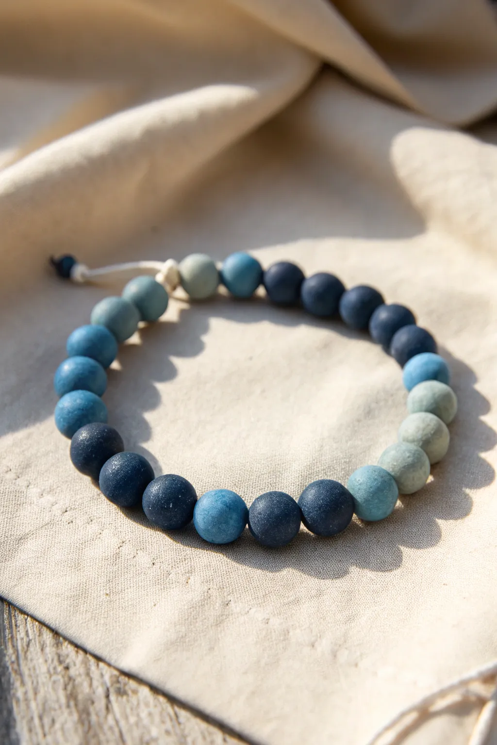 Monochrome clay bead bracelet with a smooth gradient from deep blue to airy sky tones.