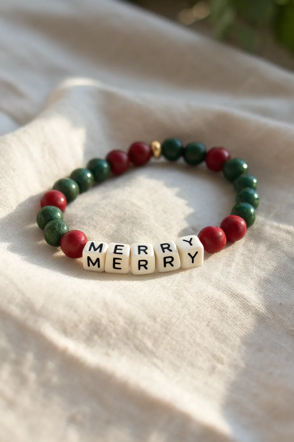 Minimalist Christmas clay bead bracelet with MERRY letter beads and classic red-green accents.
