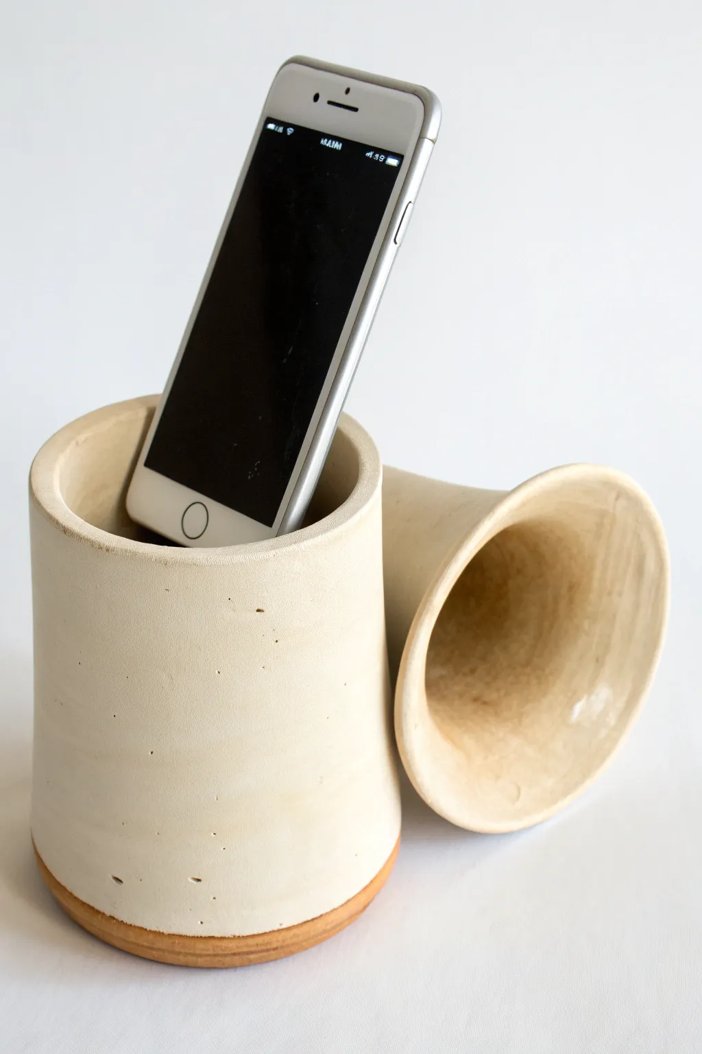 Minimal clay cylinder amp with a side horn, simple matte glaze and warm Scandinavian calm