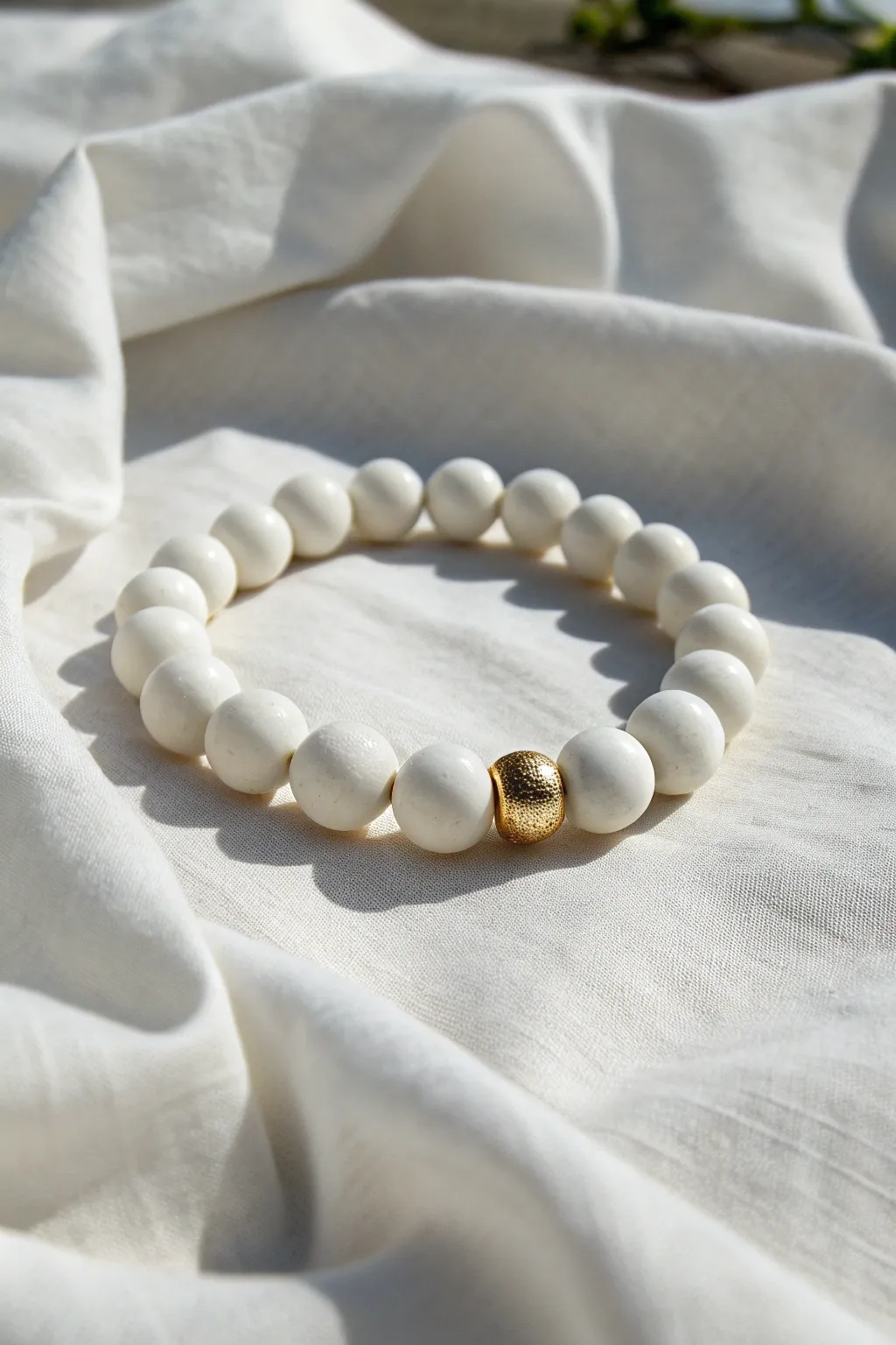 All-white clay bead bracelet with one brushed gold spacer for a clean, modern focal point.