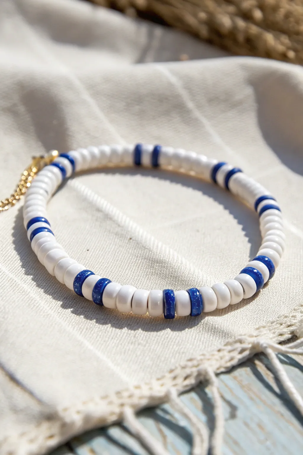 White heishi bracelet with thin blue stripe accents for a crisp, summery minimalist look