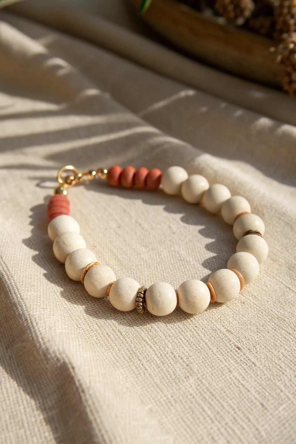 Minimal monochrome clay bead bracelet with a tiny terracotta accent for an effortless pop.