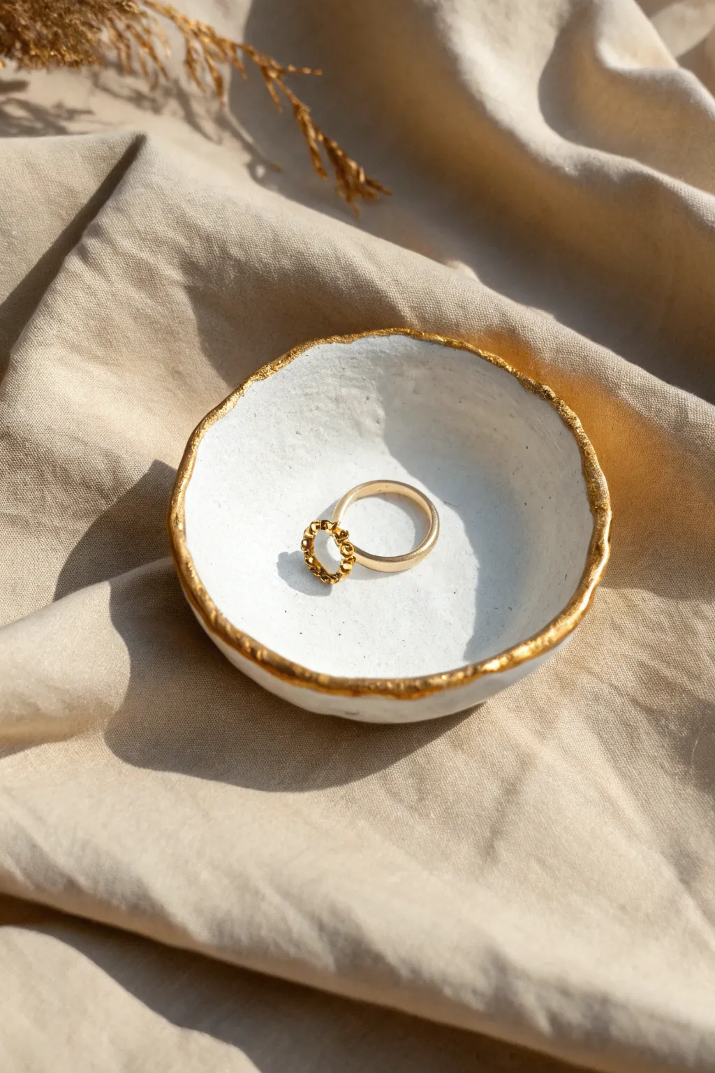 Minimal white clay ring dish with an imperfect gold rim, styled simply for a chic boho touch