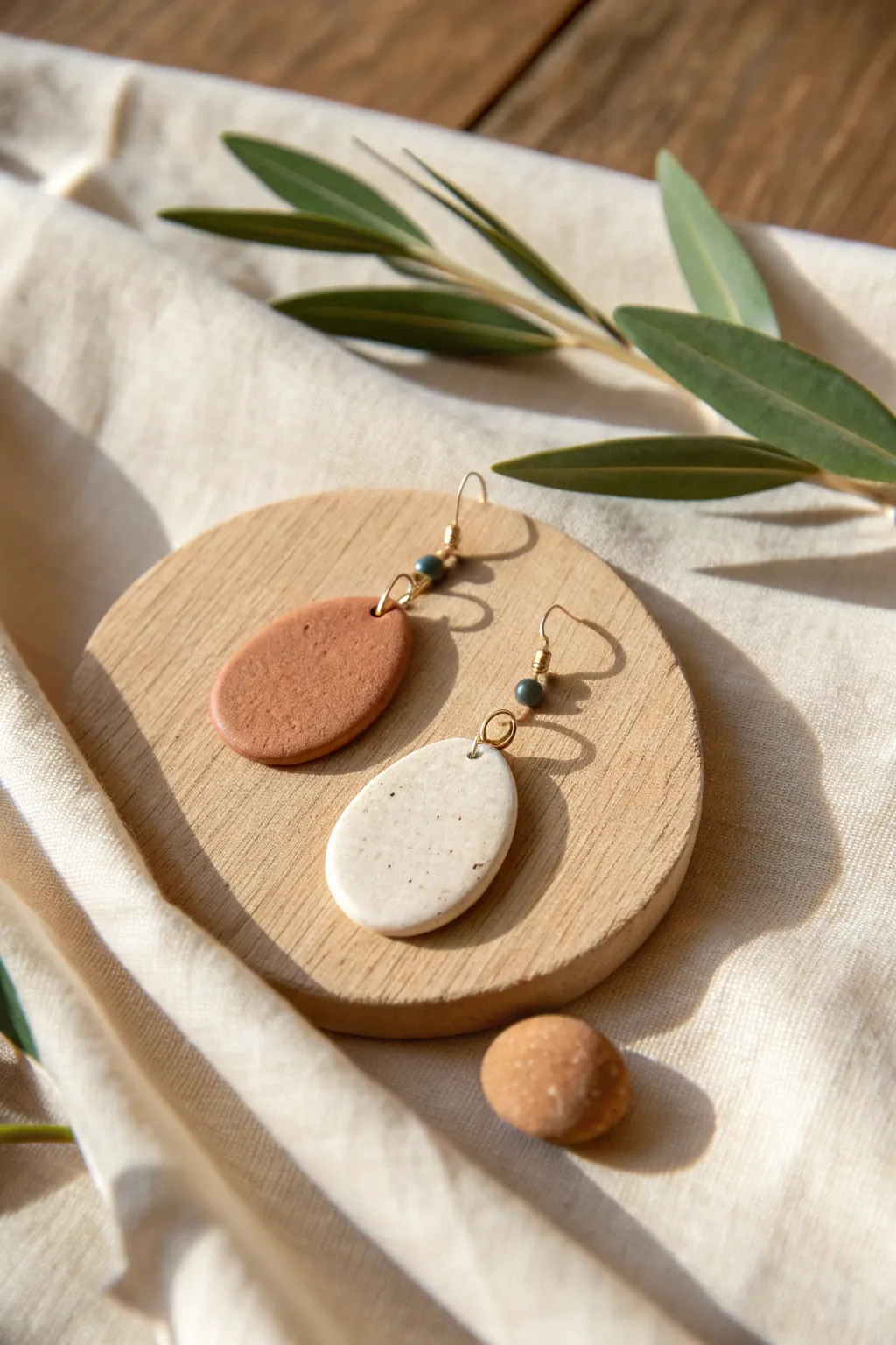 Earth tone oval drop clay earrings in terracotta, sand, sage and cream with cozy minimal styling