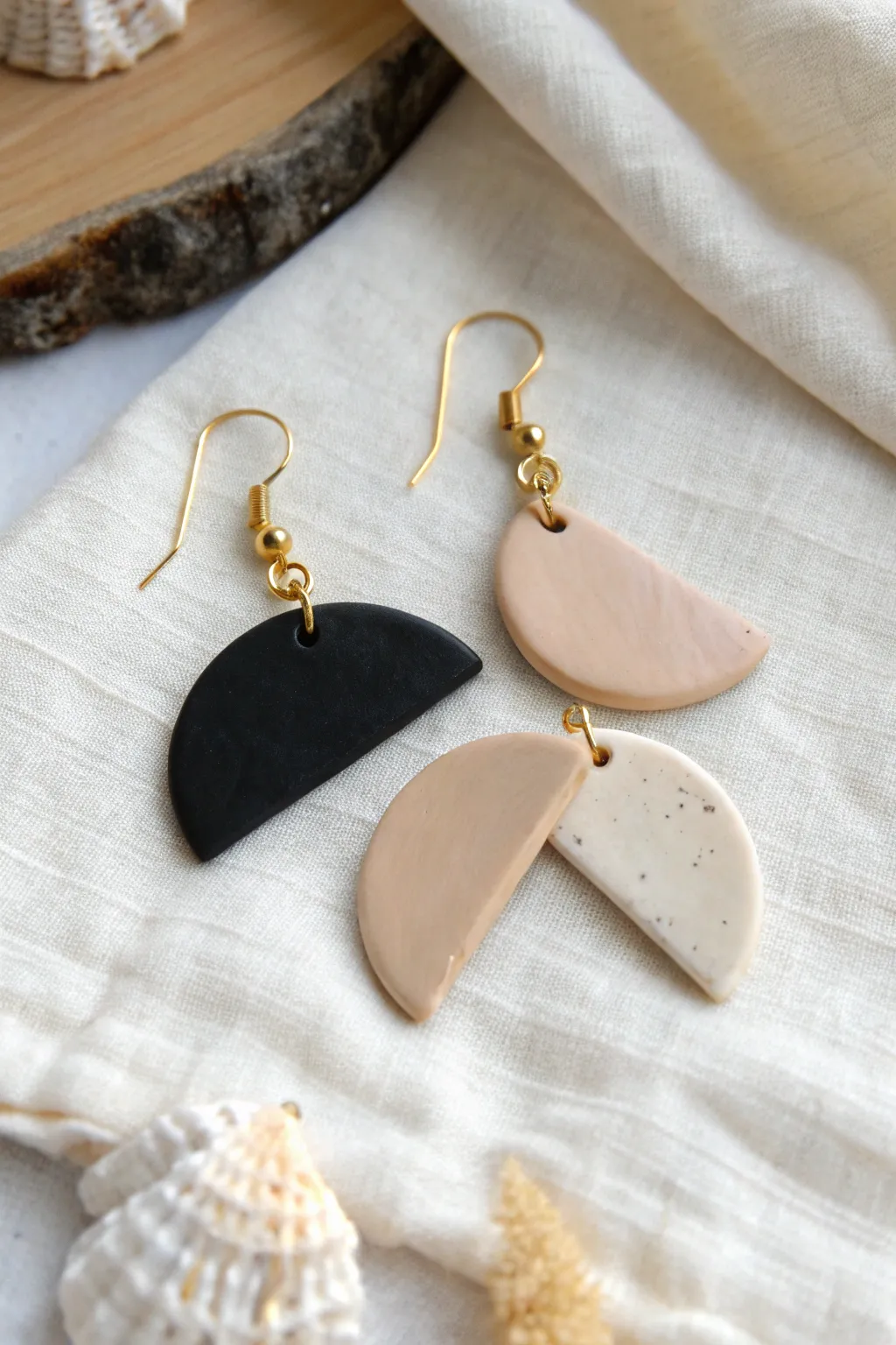 Minimal half-moon clay drops in matte black and beige, modern, handmade, and effortlessly chic.
