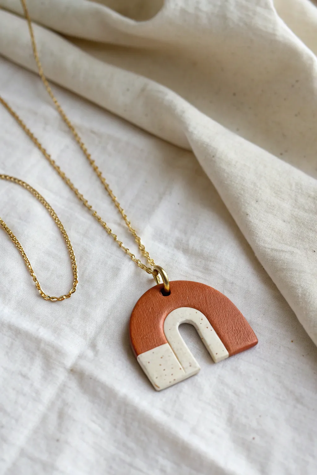Two-tone arch clay pendant on a delicate chain, minimalist boho charm for everyday outfits.