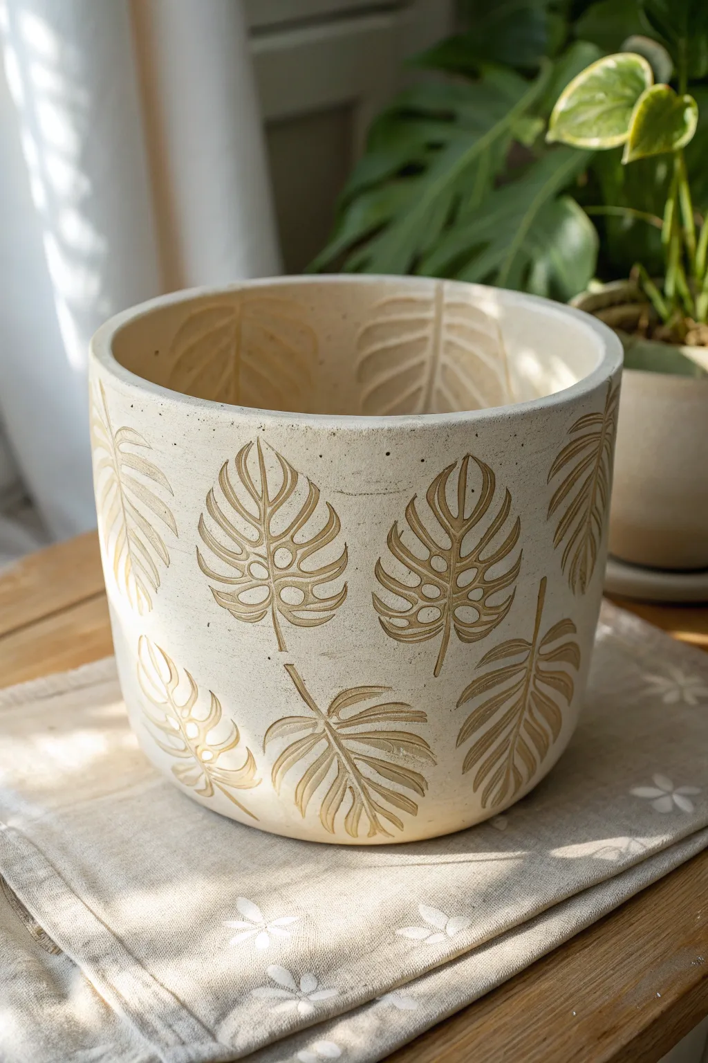 Bold monstera leaf stamps create a clean tropical texture on a minimalist handmade planter