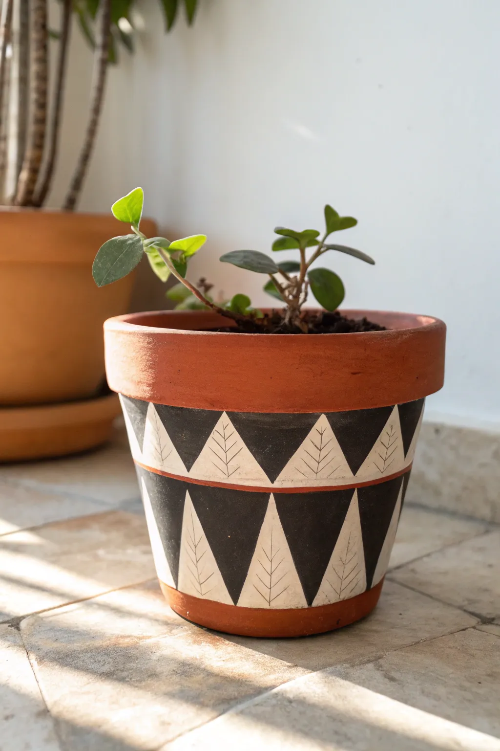 Tape-resist triangles turn a simple terracotta pot into a bold, modern accent with boho calm.