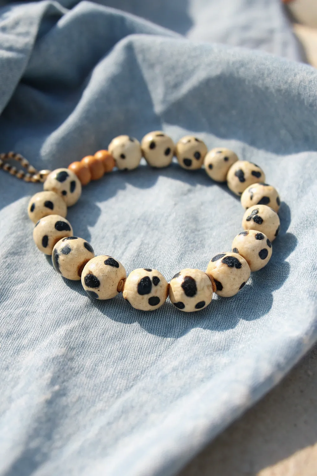 Cow print clay disc bracelet styled on denim for an easy country look with modern minimal charm