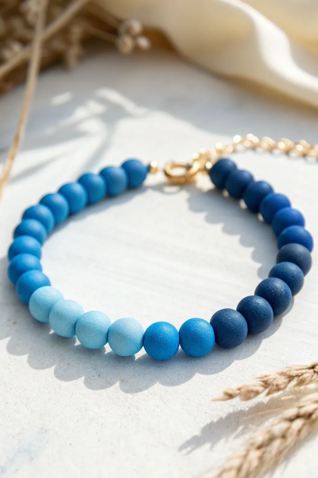 Light-to-dark blue ombré clay bead bracelet in a clean minimalist circle layout