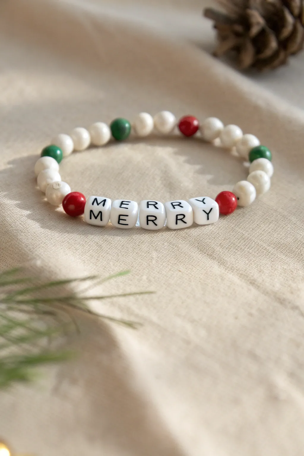 Minimalist clay bead bracelet with MERRY centerpiece, framed by red and green holiday beads.