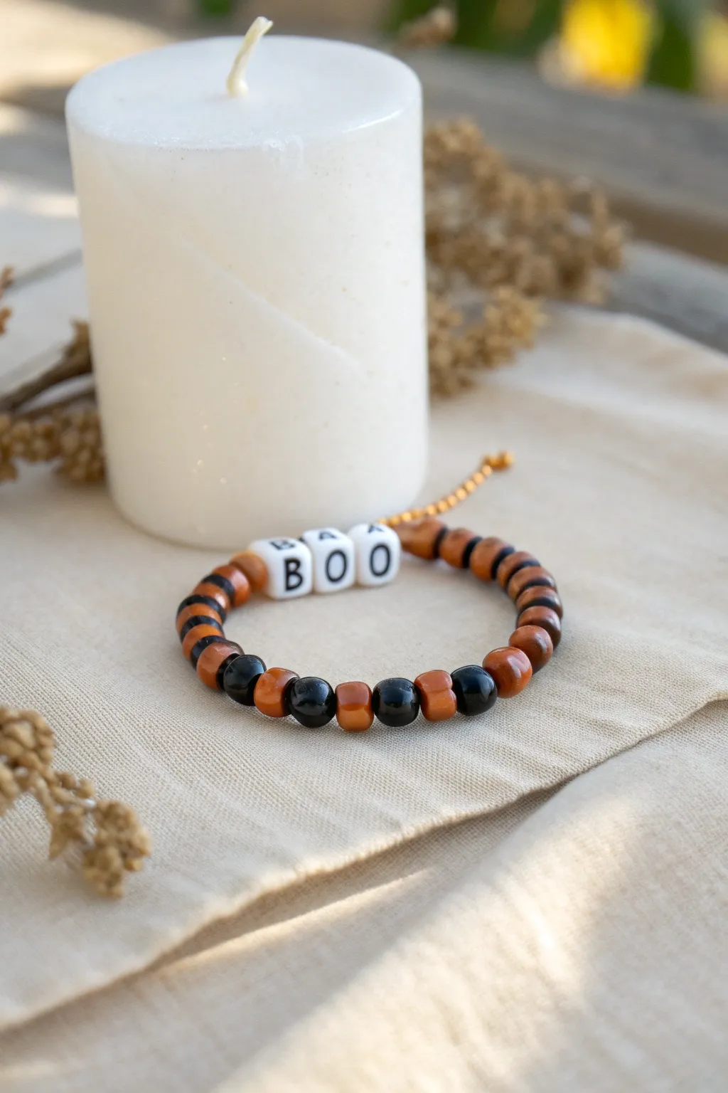 Minimal black and orange heishi bracelet with BOO letter beads, perfect for cute Halloween vibes.