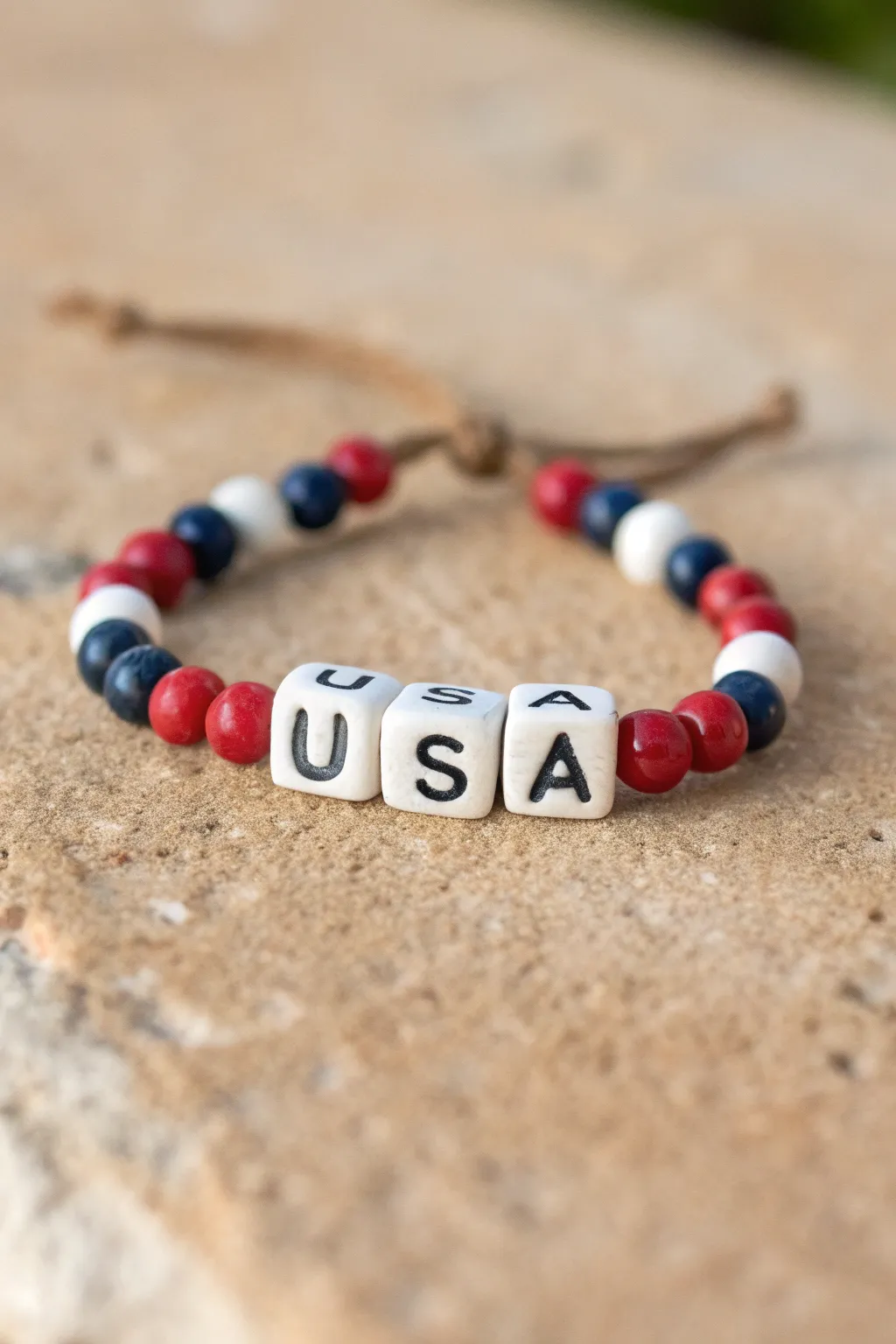 Minimal Fourth of July clay bead bracelet with USA centerpiece and classic red white blue beads.