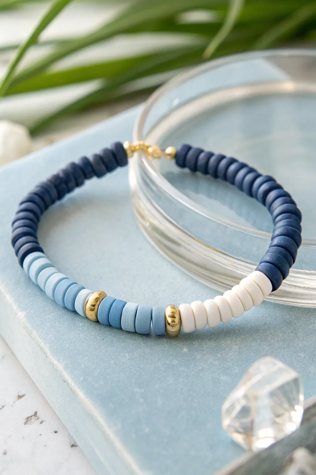 Monochrome blue heishi clay bracelet with subtle neutral spacers, clean minimal Scandinavian style