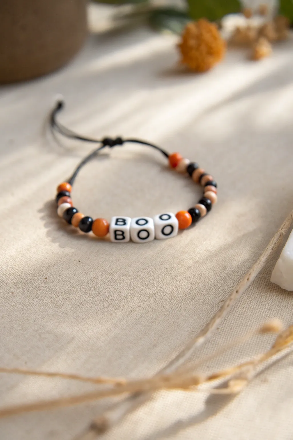 Spooky-chic BOO bracelet with orange and black heishi beads, minimalist, feminine, and handmade