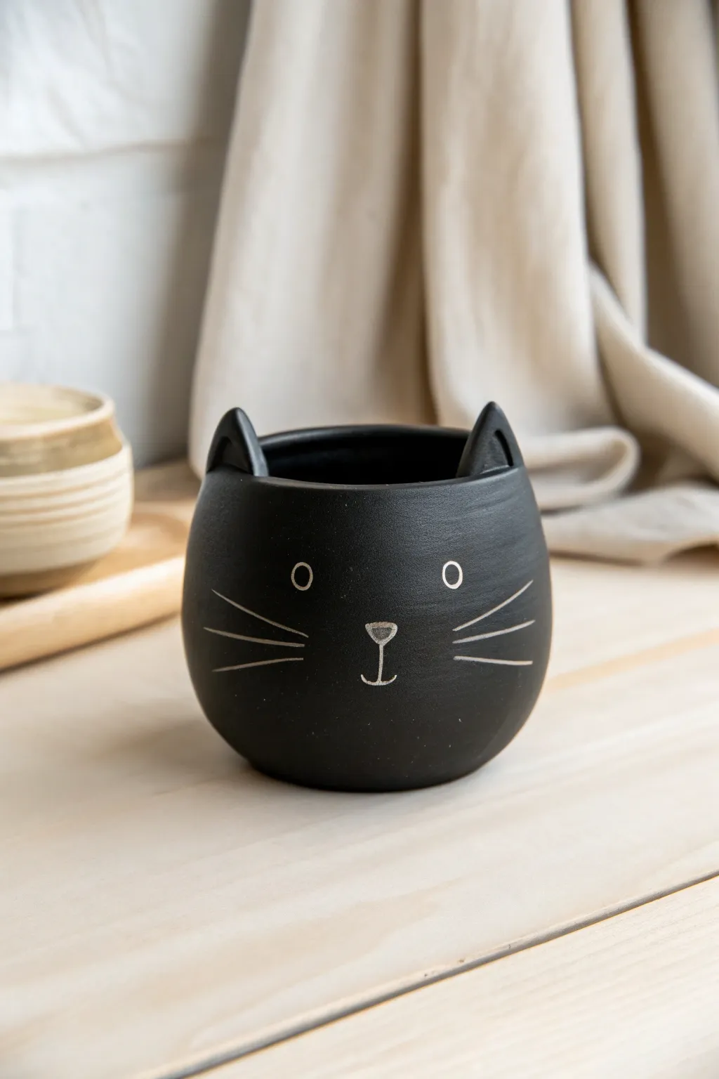 Matte black cat whisker pot with tiny ears, a minimal Halloween accent for shelves or desks