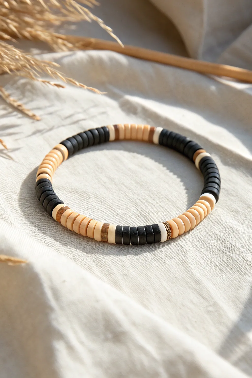 Simple two-color striped heishi bead bracelet flat lay, minimalist Scandinavian boho contrast.