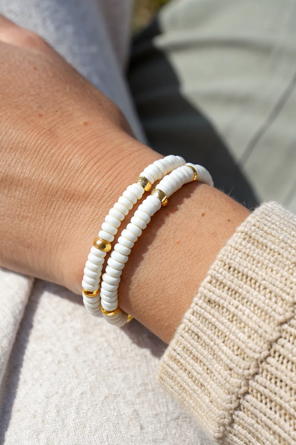 All-white heishi clay bead bracelet with gold pops, styled solo for clean minimalist charm.