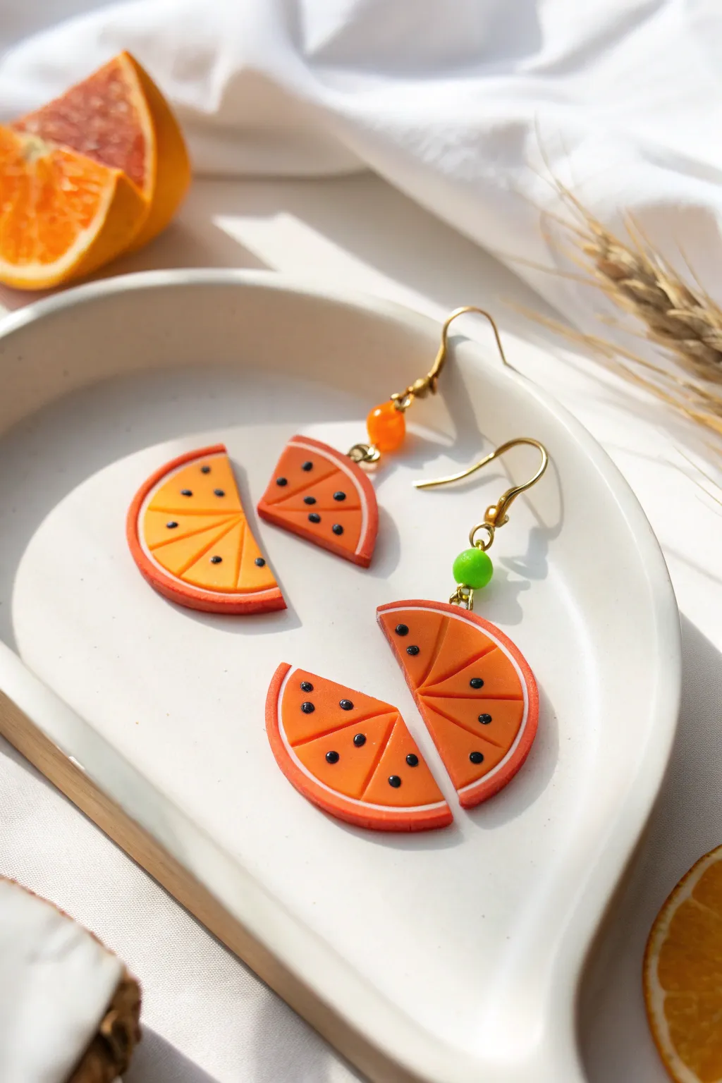 Bright fruit slice clay earrings with crisp color blocks, styled in a clean minimalist setup