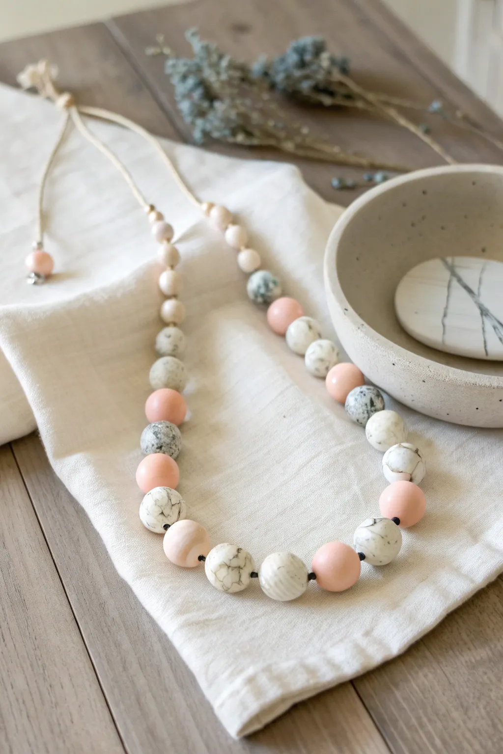 Chunky marbled polymer clay bead necklace styled simply on linen for calm Scandinavian vibes
