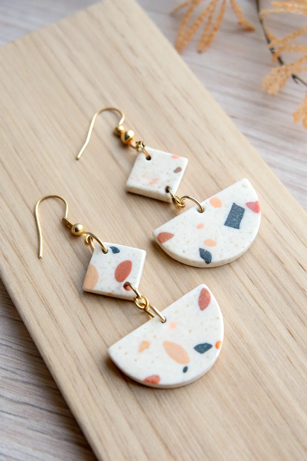 Simple terrazzo polymer clay dangle earrings on pale wood, minimalist Scandinavian boho vibe