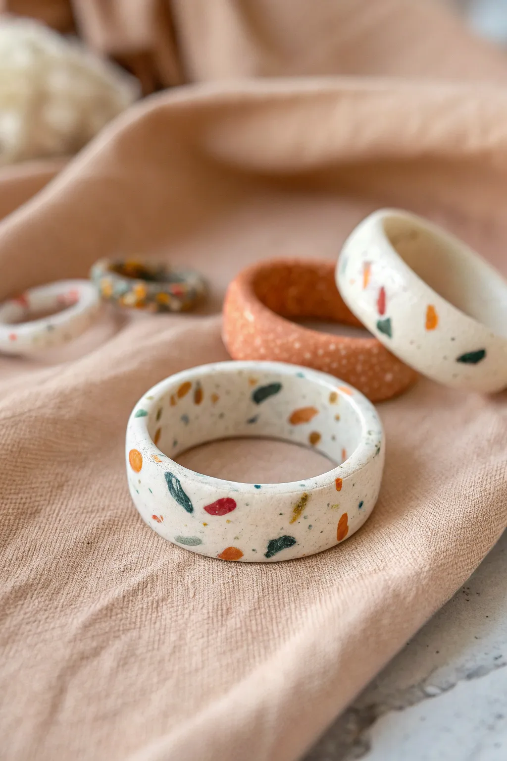 Terrazzo confetti band rings in soft modern colors, a minimal handmade look with cozy texture.