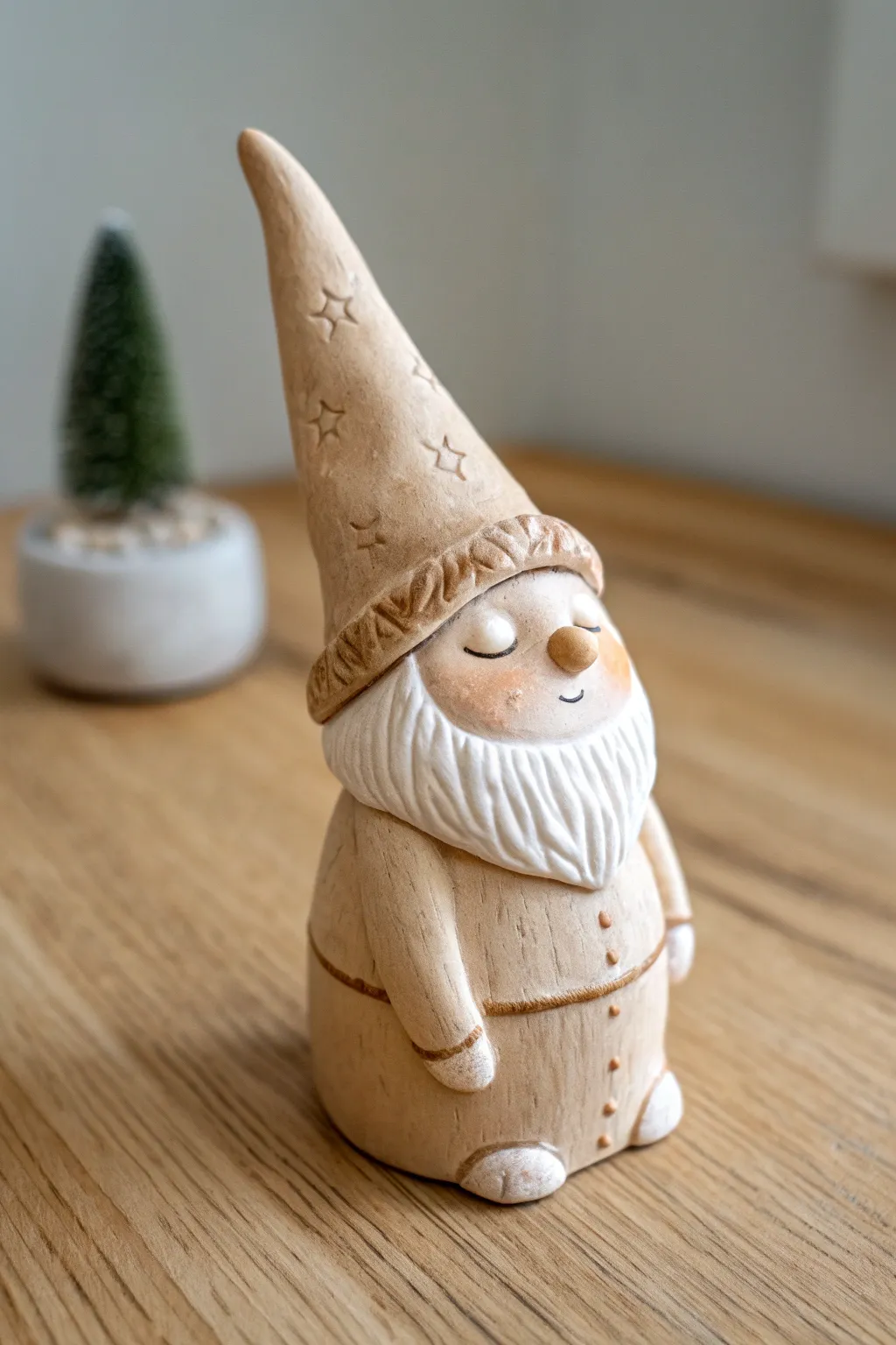 Sleepy slumped-hat clay gnome in calm neutrals, a cozy minimalist touch for your shelf.