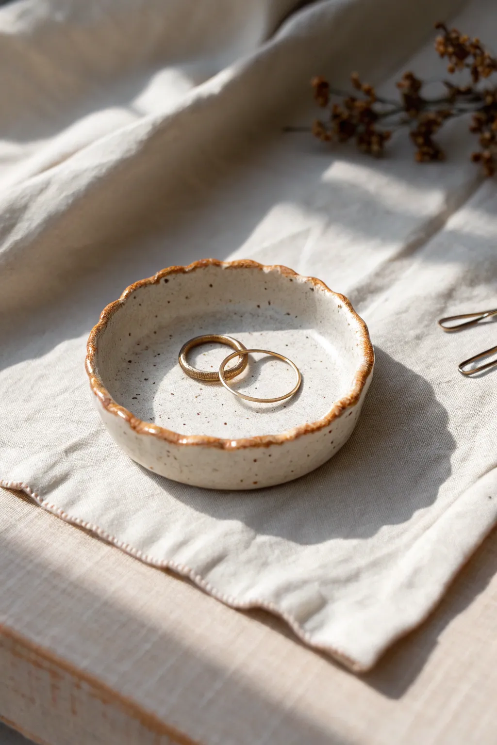 A simple round ring dish with a pinched rim—perfect for rings and a couple of pins.