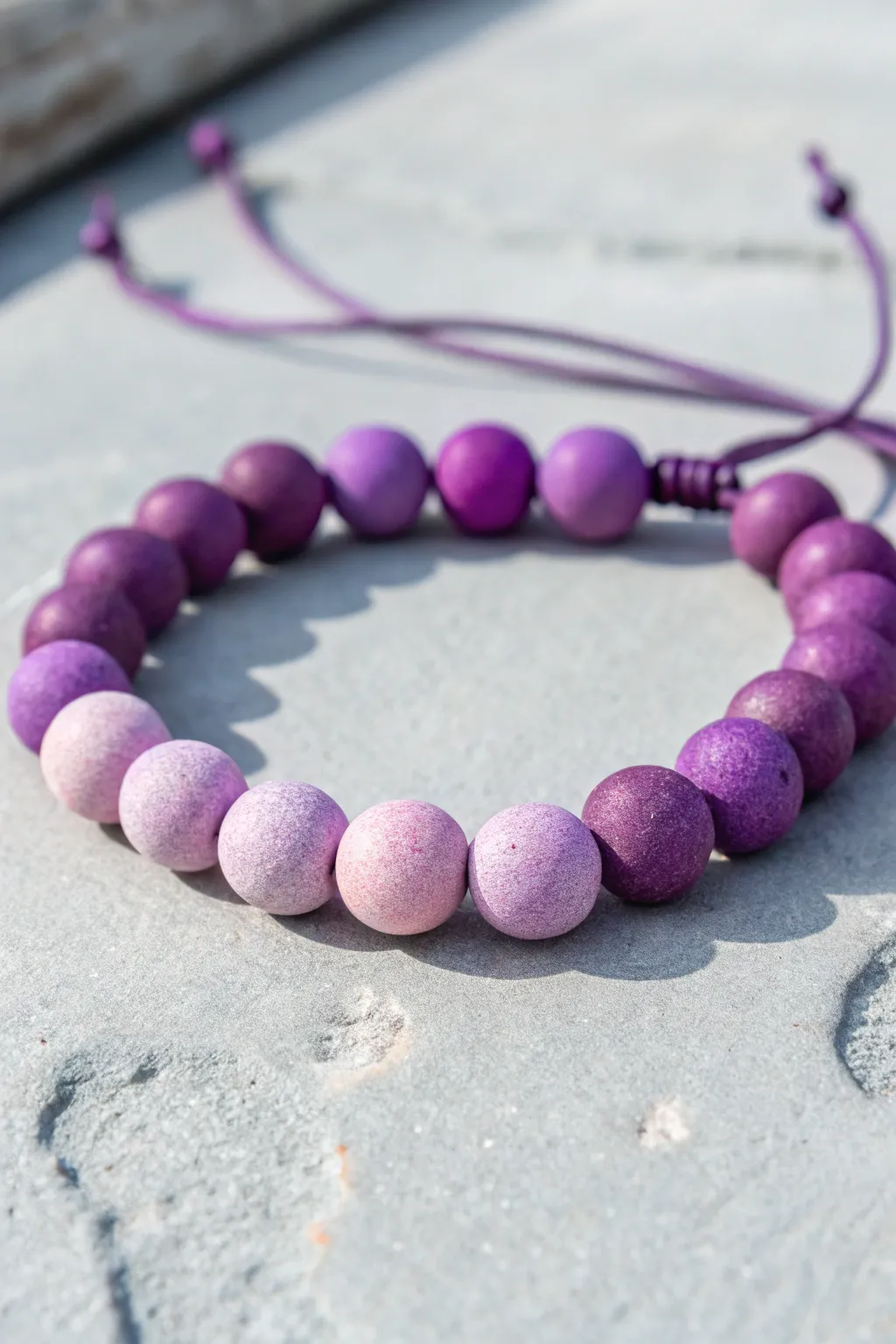 Purple ombré clay bead bracelet, deep plum to lilac gradient in clean minimalist style.