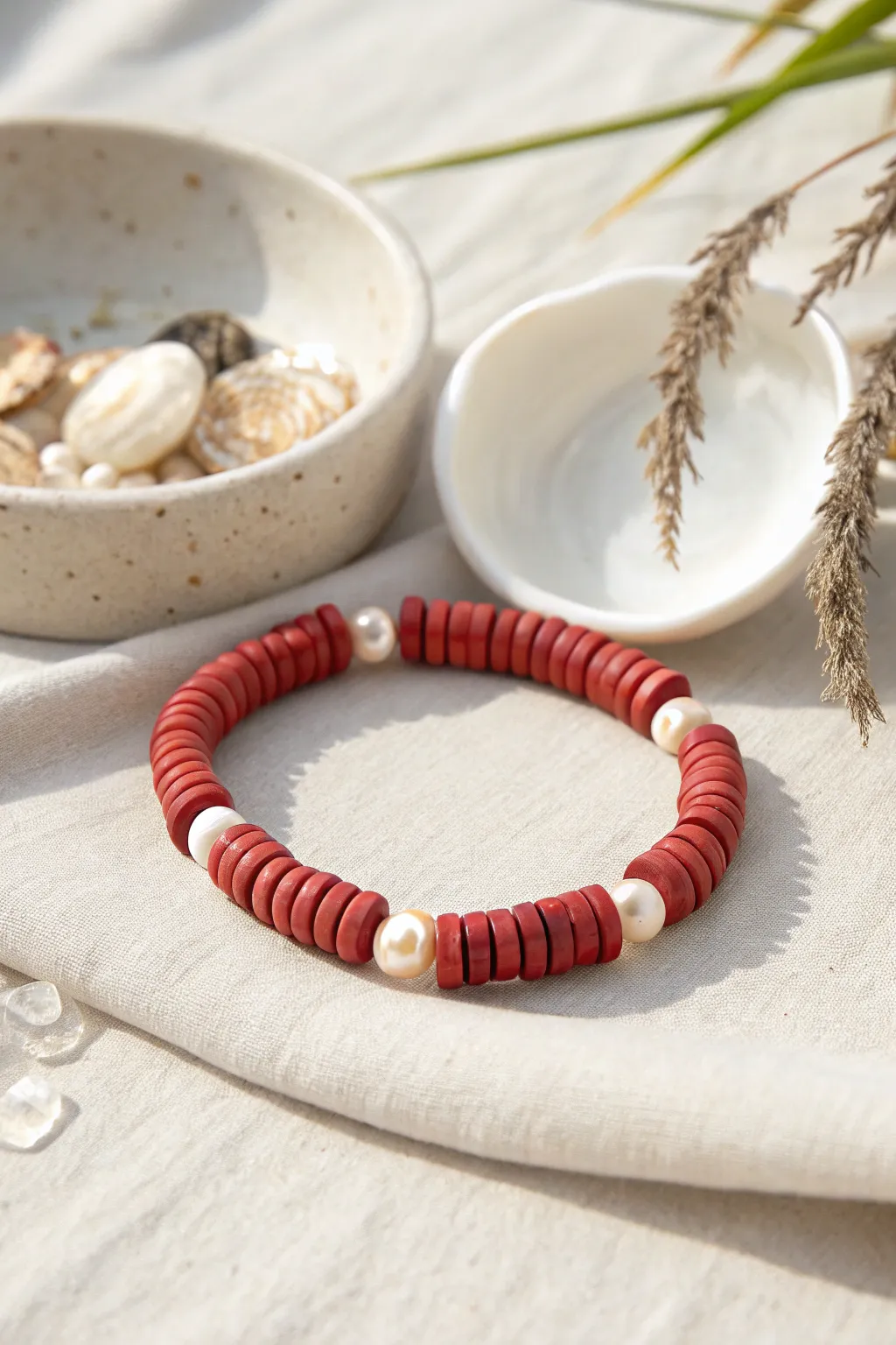 Red heishi clay beads meet soft pearls for a minimalist boho bracelet with warm, earthy glow.