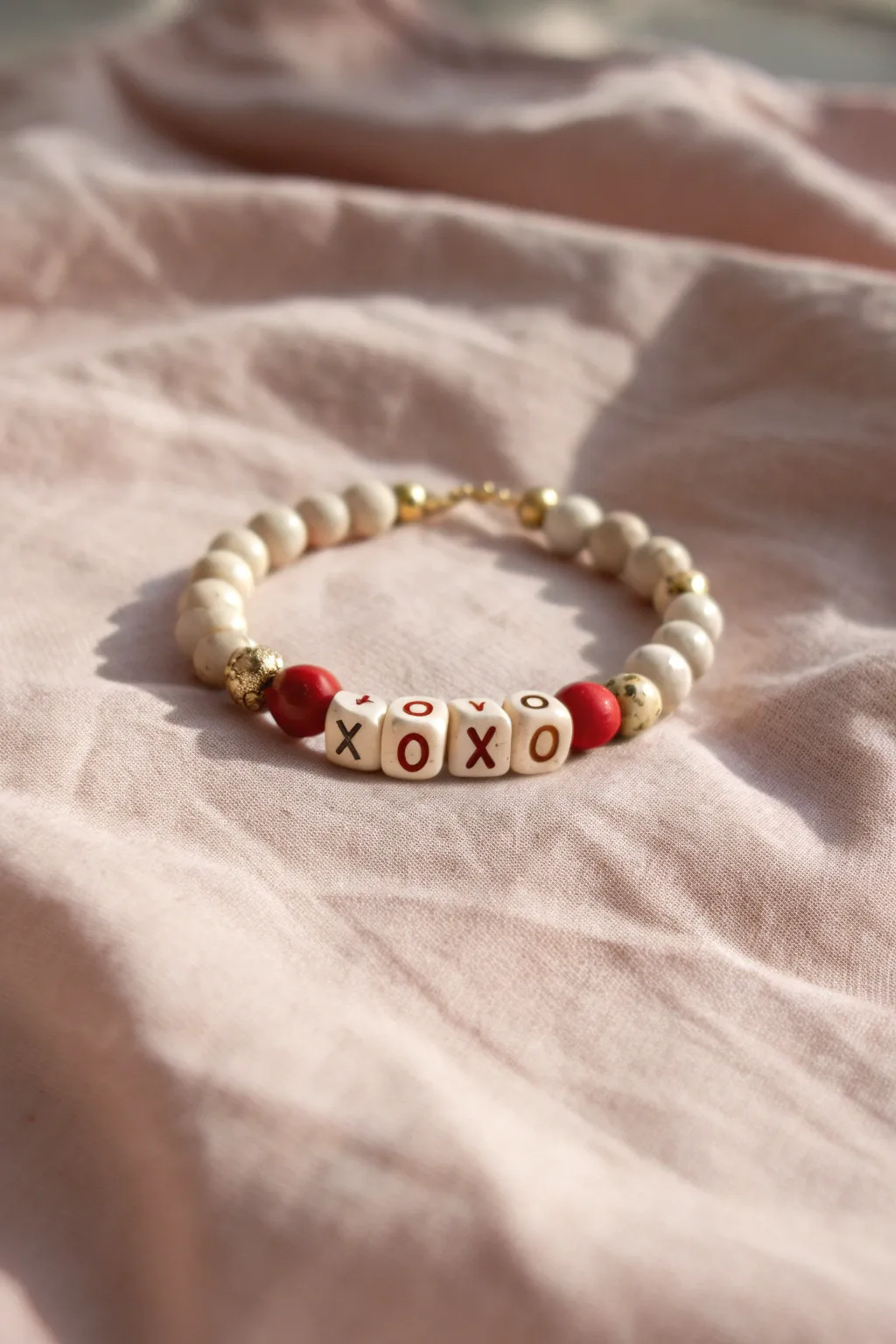 Sweet minimalist XOXO clay-disc bracelet with gold spacers, perfect for Valentine gifting.